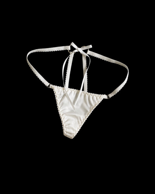 White lingerie slip with a tie at the back on a black background