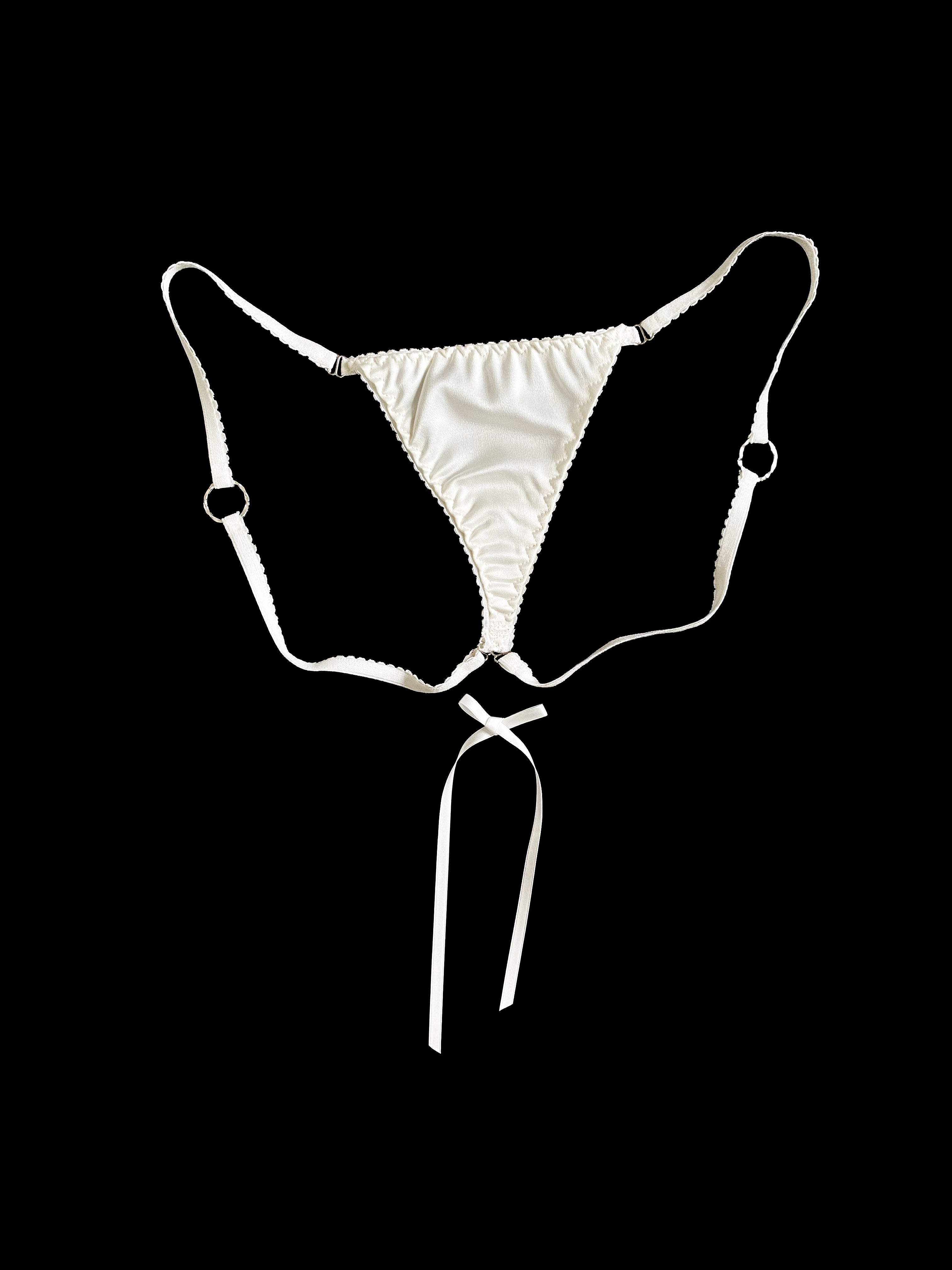 White lingerie slip with a tie on a black background